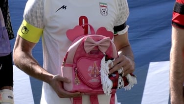 Iranian players hold schoolbags in protest over girls killed in school strike