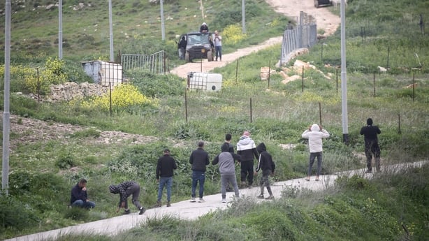 Palestinians throw stones at Jewish settlers as they attempt to establish an outpost in Palestinian agricultural fields at the site where Jewish shepherd Shmuel Sherman was killed in the village of Beit Imrin, north of Nablus in the West Bank