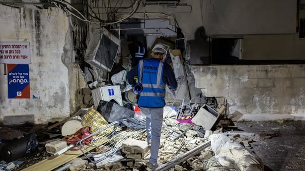 Workers inspect a building damaged by a strike in Tel Aviv, on March 28, 2026. On the evening of March 27, the Israeli army reported missiles fired by Iran at Israel. (Photo by Ilia YEFIMOVICH / AFP) / 