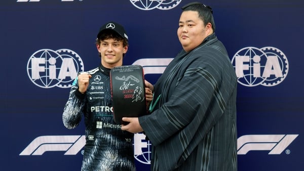 SUZUKA, JAPAN - MARCH 28: Andrea Kimi Antonelli of Italy and Mercedes AMG Petronas F1 Team poses with the Pirelli Pole Position award presented to him by Japanese Sumo wrestler Kotozakura Masakatsu during qualifying ahead of the F1 Grand Prix of Japan at