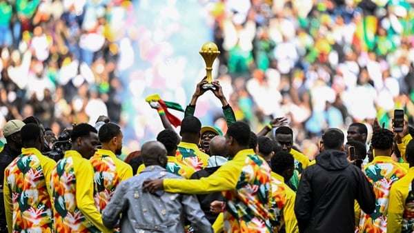 Senegalese musician Youssou N'Dour (C) holds The African Cup of Nations Trophy as Senegal's players gather around him ahead of the international friendly football match between Senegal and Peru at the Stade de France