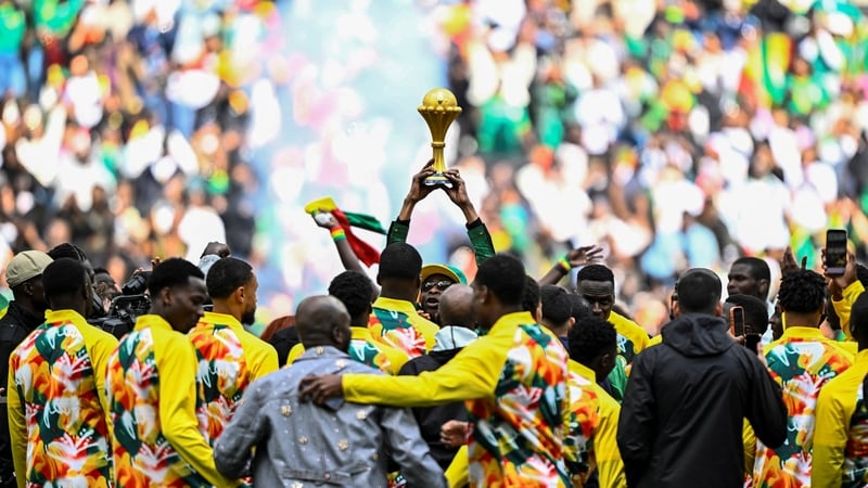 Senegalese musician Youssou N'Dour (C) holds The African Cup of Nations Trophy as Senegal's players gather around him ahead of the international friendly football match between Senegal and Peru at the Stade de France