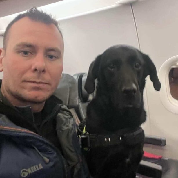 Search and rescue volunteer Ryan Gray and his trained dog Max on a plane