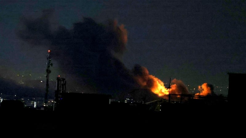 A plume of smoke rises from the site of a strike in Tehran