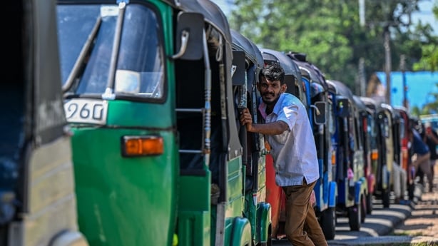 Drivers wait in a queue to refuel their auto rickshaws at a fuel station in Biyagama on the outskirts of Colombo