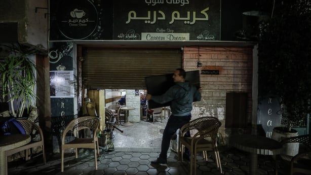 People walk past shops in Cairo as Egypt begins implementing government measures aimed at reducing energy consumption amid rising global oil prices linked to ongoing Israeli and U.S. attacks on Iran in Cairo, Egypt, on March 2026. Under the new measures, restaurants and retail stores are required to