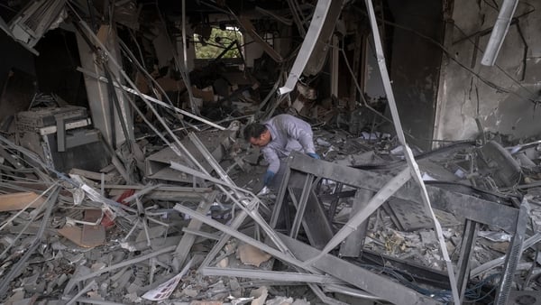 A man searches for belongings among the ruins of a commercial-office building in a residential area of Tehran