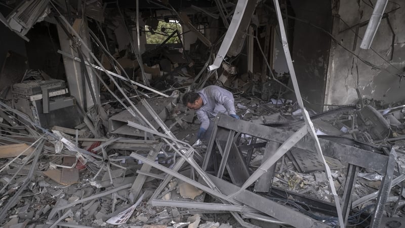A man searches for belongings among the ruins of a commercial-office building in a residential area of Tehran