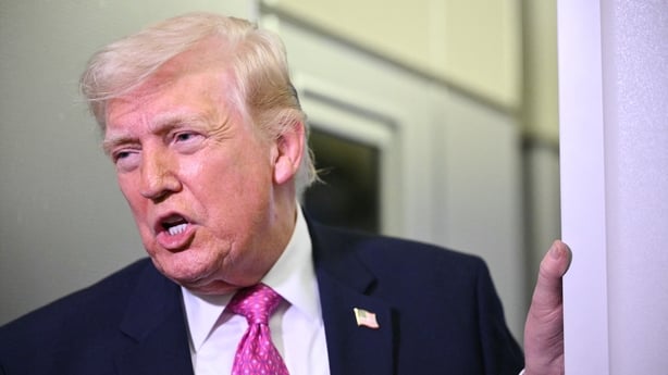 US President Donald Trump speaks to reporters aboard Air Force One