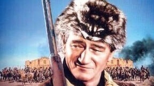 poster for John Wayne film The Alamo, title above image of John Wayne in fur hat with gun over shoulder