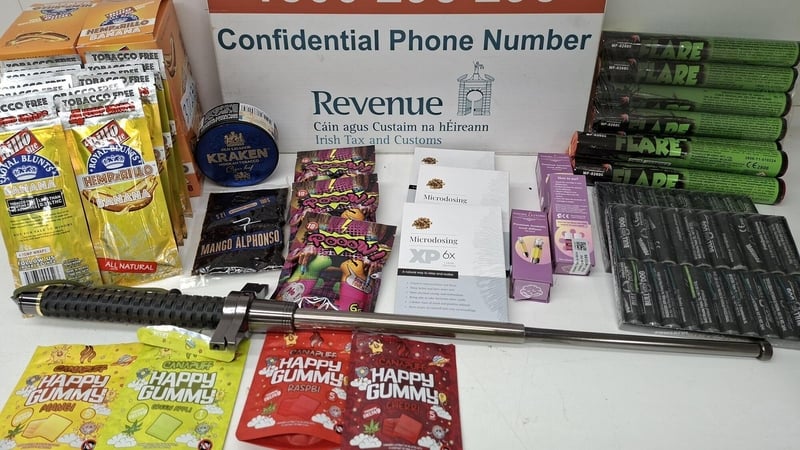Image shows a table displaying various brightly coloured packets of drugs and contraband