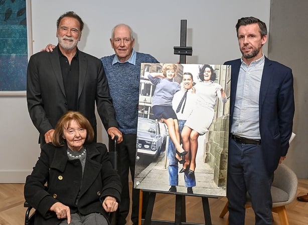 Arnold Schwarzenegger with Sandra Weir (in wheelchair and left on the photo on the easel) and Belfast Telegraph photographer Roy Smith, (third left), and guest