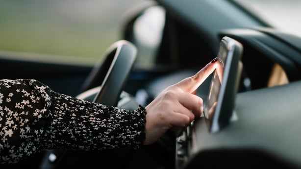 Detail of a woman touching with her finger a car's touch screen