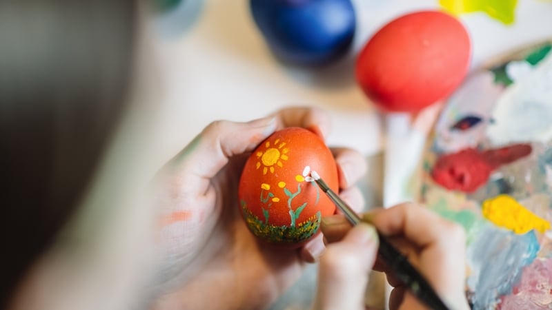 Close up of girl's hands painting on Easter egg