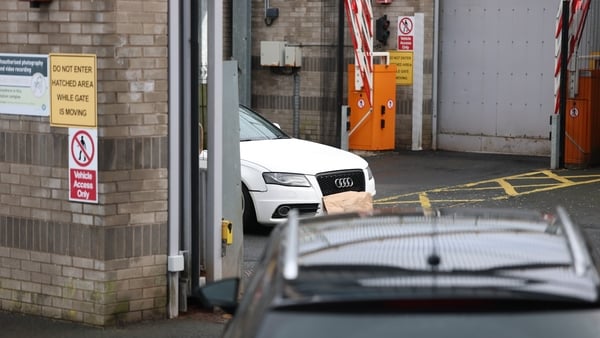 A white Audi car parked inside a police station with licence plate covered by brown paper