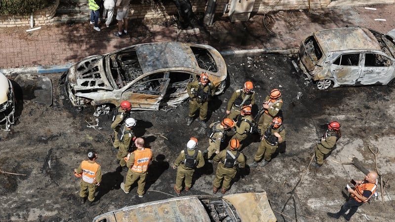 First responders stand by the wreckage of vehicles as they work at a site hit during an Iranian strike over Petah Tikva on March 31, 2026. Iran fired missiles across the Middle East on March 31 as its capital was hit by fresh explosions, after US Presiden