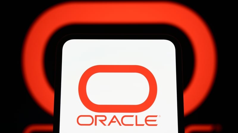 The logo of the American company Oracle appears on a smartphone screen in front of a computer screen displaying the company logo in Creteil, France, on March 10, 2026, as the technology giant announces its third-quarter financial results. (Photo by Samuel