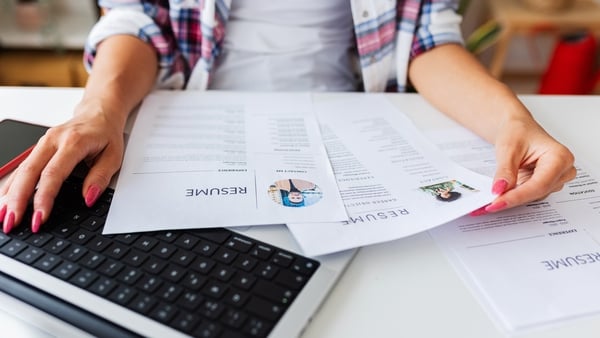Close up view of Human Resources female hands reading CV of job candidates. Recruitment human resources employment hiring concept.