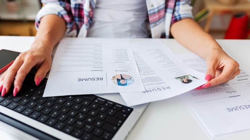 Close up view of Human Resources female hands reading CV of job candidates. Recruitment human resources employment hiring concept.