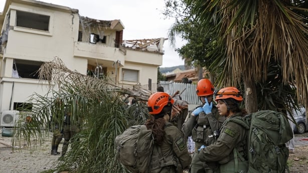 Israeli security forces gather at the site of a Hezbollah missile strike that targeted a house in the northern Israeli town of Kiryat Shmona near the border with Lebanon