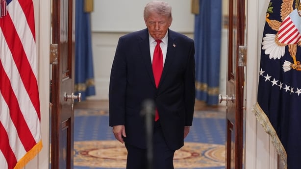 US President Donald Trump arrives for a prime-time address to the nation in the Cross Hall of the White House.
