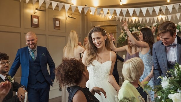 Bride standing talking to a woman at her wedding reception