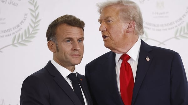 This photograph shows donald trump talking to emmanual macron as they pose for a photograph in 2025