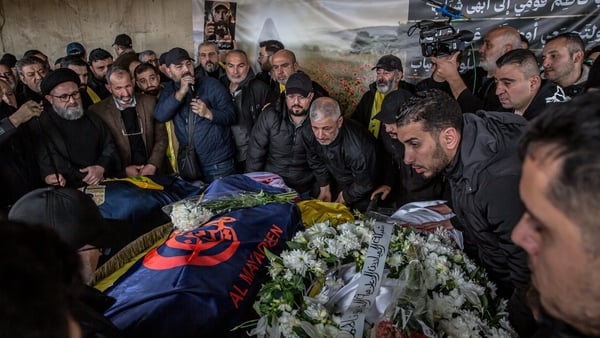 Mourners pray by coffins in Choueifat, south of Beirut, during a funeral ceremony, for three journalists killed the previous day by Israeli airstrikes