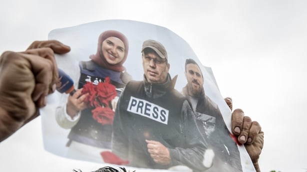 A poster is held up during a funeral ceremony in Choueifat, south of Beirut, for three journalists killed the previous day by Israeli airstrikes
