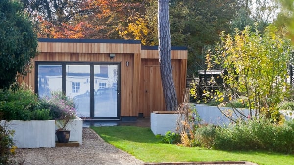 a wooden garden room with windows