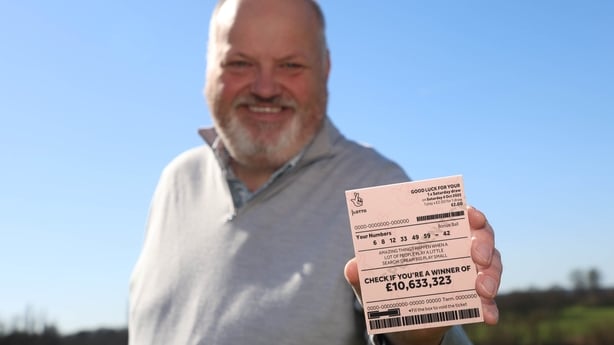 Andy Carter, Senior Winners' Advisor at The National Lottery holds up the winning ticket