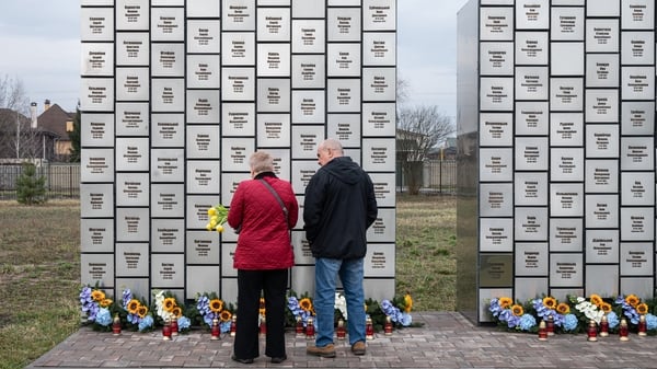 People stand in front of the memorial during a commemorative event for victims of the Bucha massacre in Ukraine