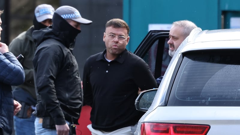 Jonathan Gill wearing glasses pictured at the High Court alongside officers