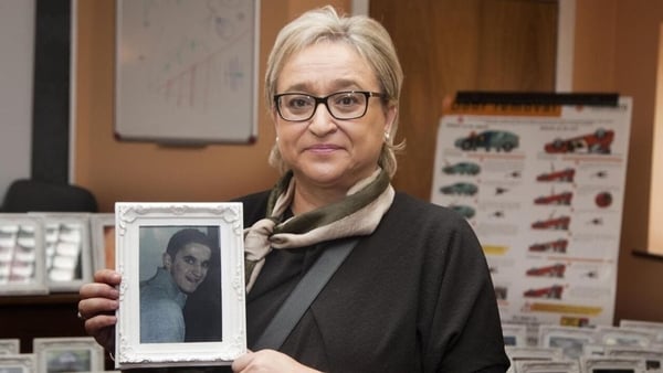 Donna Price holding a framed photo of her son