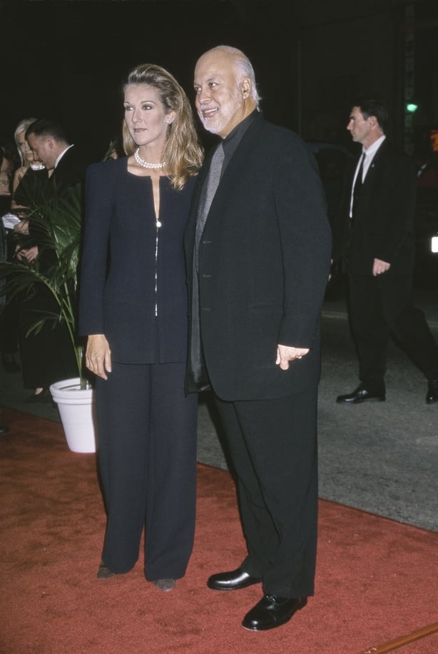 Canadian singer Celine Dion, wearing a black trouser suit, and her husband, Canadian music manager and singer Rene Angelil, who wears a black suit over a black shirt with a black-and-white fine check tie, attend the Hollywood premiere of 'Titanic' at the Mann Chinese Theater in the Hollywood neighbo