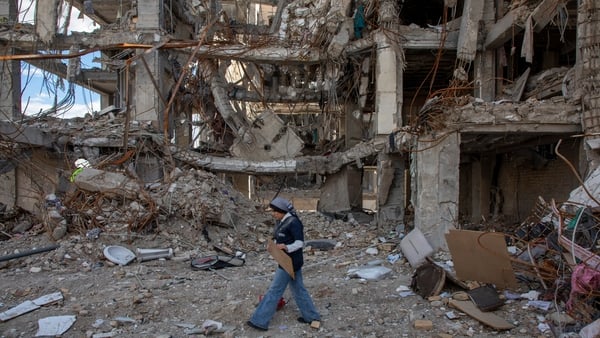 A woman walks among buildings destroyed in a joint attack by Israel and the United States in Tehran, Iran