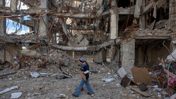 A woman walks among buildings destroyed in a joint attack by Israel and the United States in Tehran, Iran