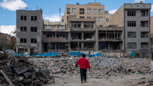 A man walks among buildings destroyed in a joint attack by Israel and the United States in Tehran, Iran