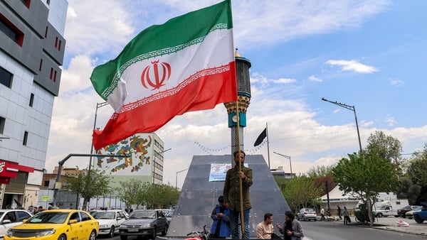 A man stands with an Iranian national flag at Valiasr Square in Tehran