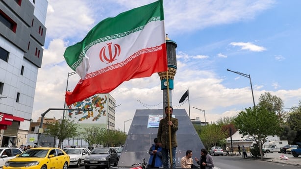 A man stands with an Iranian national flag at Valiasr Square in Tehran
