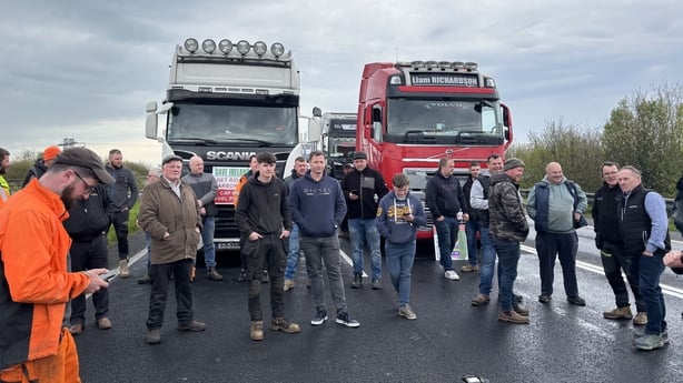 a group of people stand in front of two lorries
