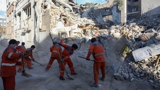 Iranian workers cleans at the site of Israeli-American strikes that according to local media reports destroyed the Rafi-Nia Synagogue and nearby residential buildings in Tehran