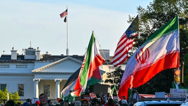 Demonstrators wave Iranian flags during a protest against US military action in Iran