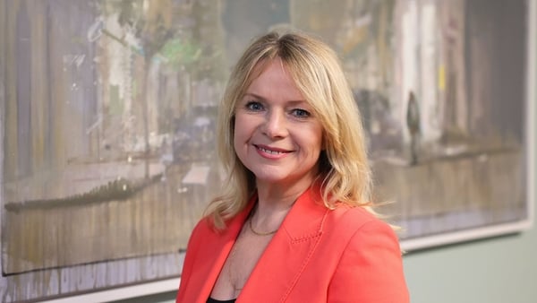 Image of a business woman in a coral jacket