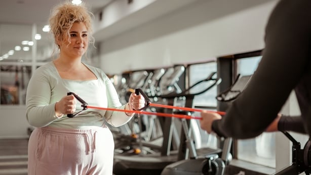 woman in the gym working out with fitness trainer