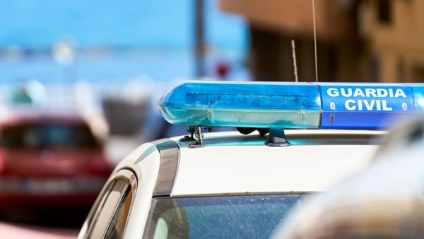 Guardia Civil car with blue lights parked on a street near the ocean, representing law enforcement and security in Spain
