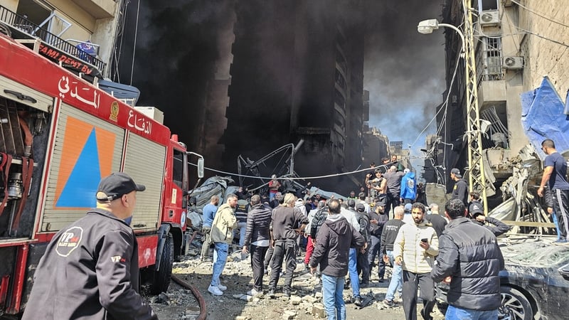 First responders and residents stand amid rubble at the site of an Israeli airstrike