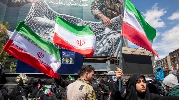  Iranians hold national flags as they gather in Tehran's Revolution Square after the United States and Iran agreed to a two-week ceasefire