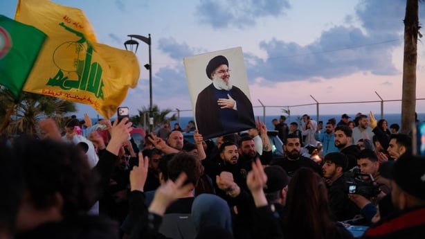 A portrait of Hassan Nasrallah is raised above the crowd during a protest in support of Hezbollah in West Beirut in Lebanon 