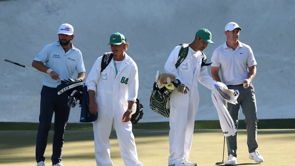 AUGUSTA, GEORGIA - APRIL 10: Cameron Young of the United States with his caddie Kyle Sterbinsky and Rory McIlroy of Northern Ireland with his caddie Harry Diamond prepare to putt on the 13th green during the second round of the 2026 Masters Tournament at